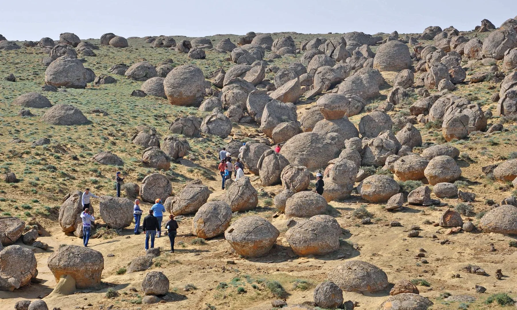 Large stone spheres of varying sizes scattered across open steppe.