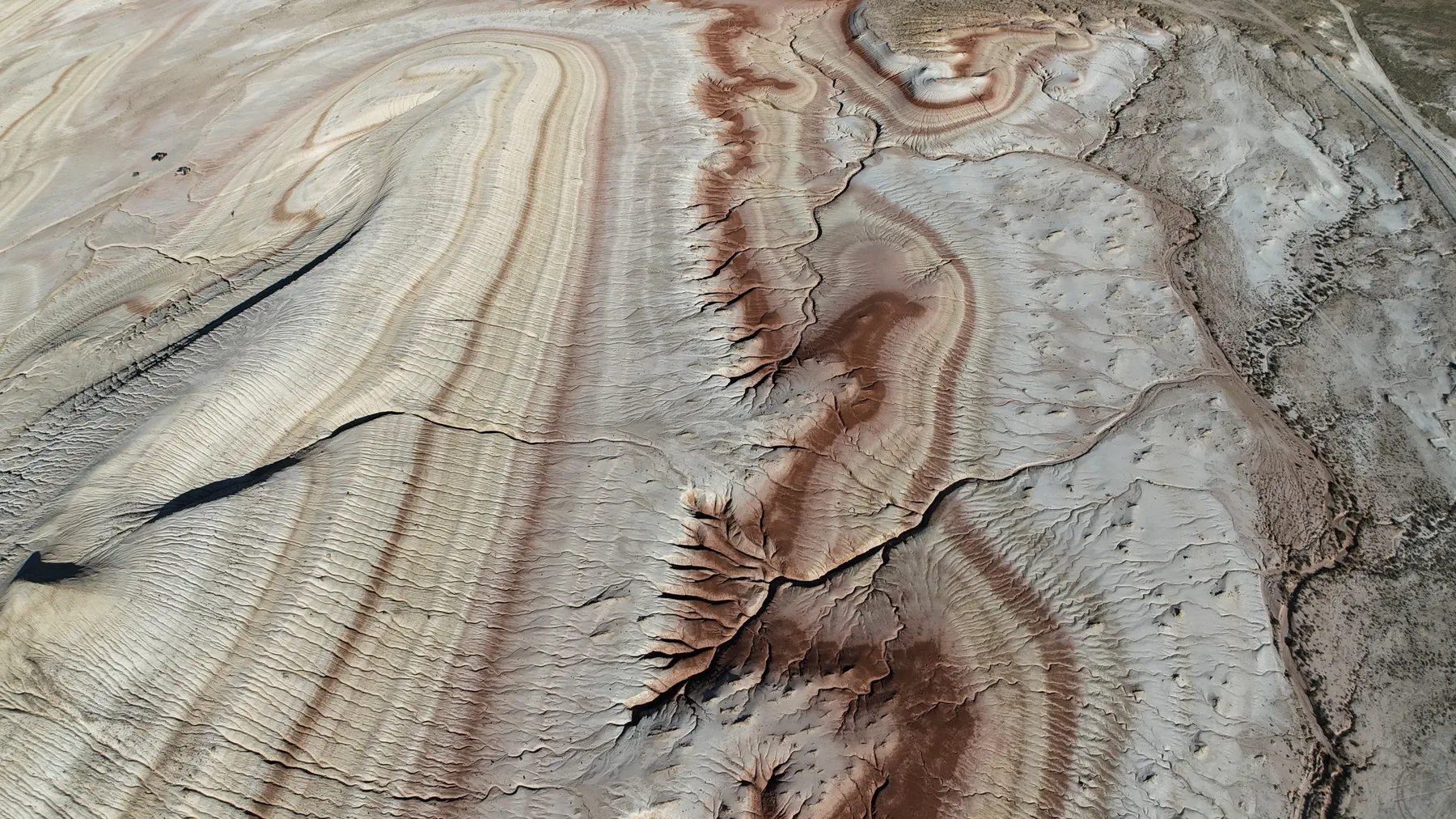 Low hills banded in red, ochre and white horizontal stripes.
